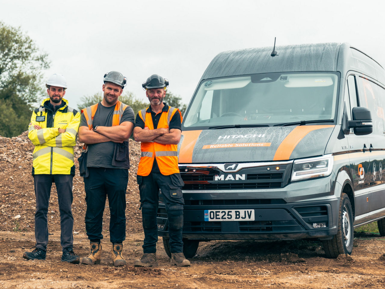 Satisfied TGE users: Paul Breheny (left), Dean Barraclough (right) and a colleague in front of one of the 72 vehicles in Hitachi Construction Machinery UK's fleet.
